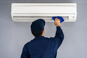 technician service cleaning air conditioner with cloth
